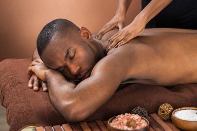 Close-up Of Happy African Man Receiving Massage Treatment